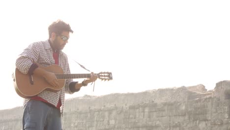 pareja feliz de mochileros turistas en un tronco de madera tocando la guitarra cantando leyendo un libro frente al antiguo acueducto romano ruinas en el romántico parque degli aquedotti parque en roma al amanecer cámara lenta