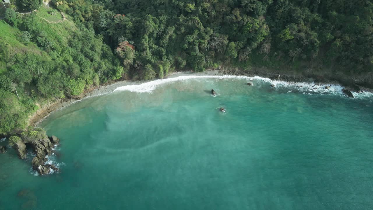 Drone view of a waves crashing at a cliffside beach on the Caribbean island of Tobago