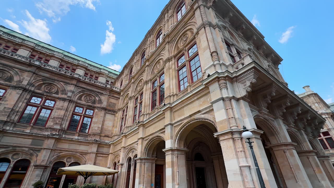 Vienna, Austria - June 9, 2025: Stunning building of Vienna State Opera in Austria. Tour by the street of beautiful city. Low angle view