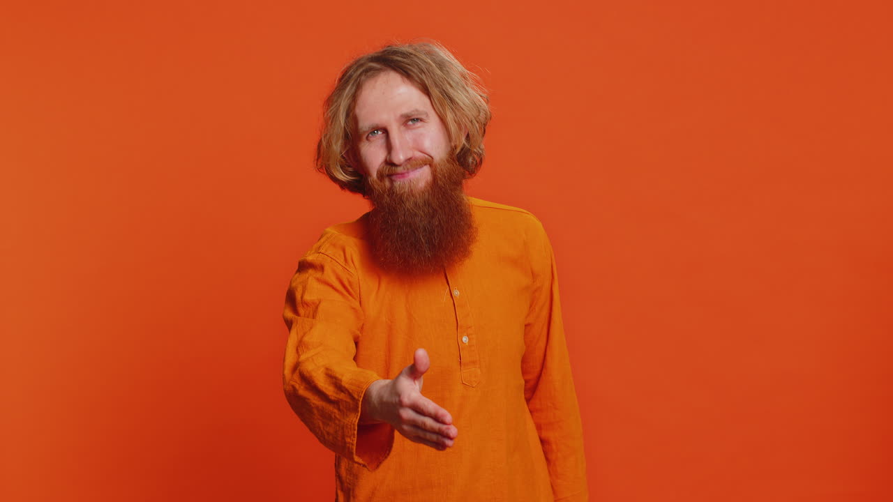 hombre caucásico extendiendo la mano a la cámara ofreciendo un apretón de manos saludando invitación de bienvenida