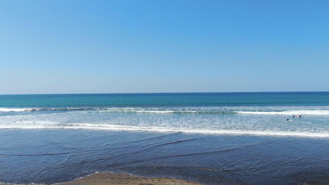 un avión no tripulado de la playa de costa rica volando a través de árboles de coco y entrando en el mar sobre el agua en el océano pacífico en un día soleado