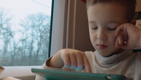 Niño-Jugando-En-El-Panel-Táctil-Durante-El-Viaje-En-Tren