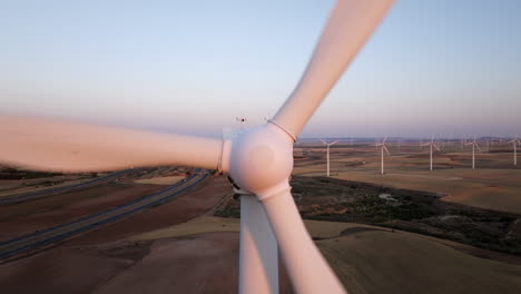 turbina eólica y granja al amanecer o al atardecer