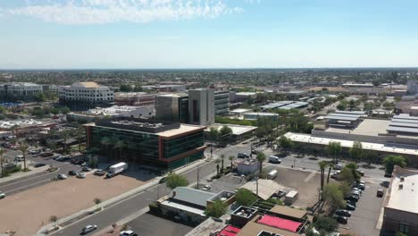 centro de la ciudad de chandler en arizona durante un día soleado. conducir coches en la carretera entre casas modernas y edificios. órbita aérea tiro de ancho.
