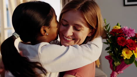two women embracing and smiling with a bouquet of flowers