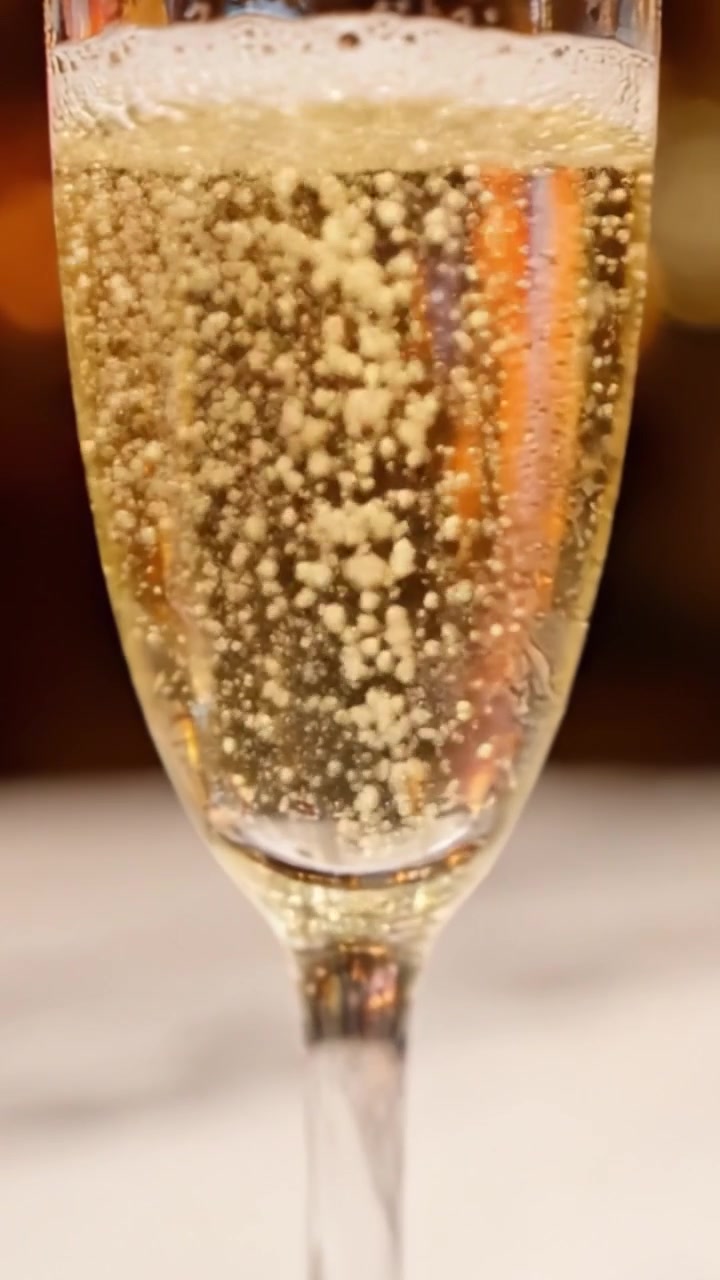 Eleganti calici da champagne che catturano le bollicine della celebrazione, mettendo in mostra perfettamente lo scintillio dorato e la natura rinfrescante del vino spumante