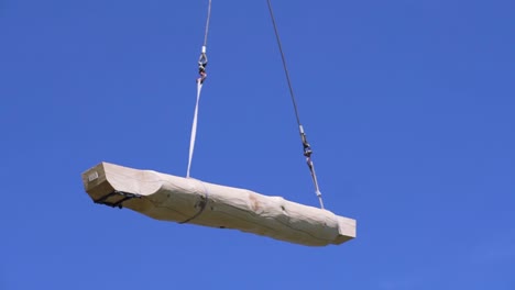 grúa que levanta una gran viga de madera