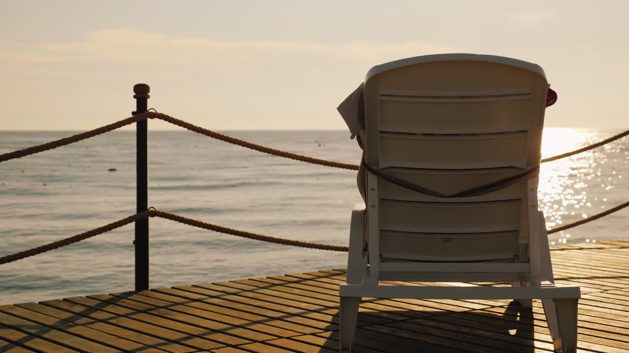 el salón para relajarse está en el muelle girado hacia el sol naciente sobre el video del mar 4k
