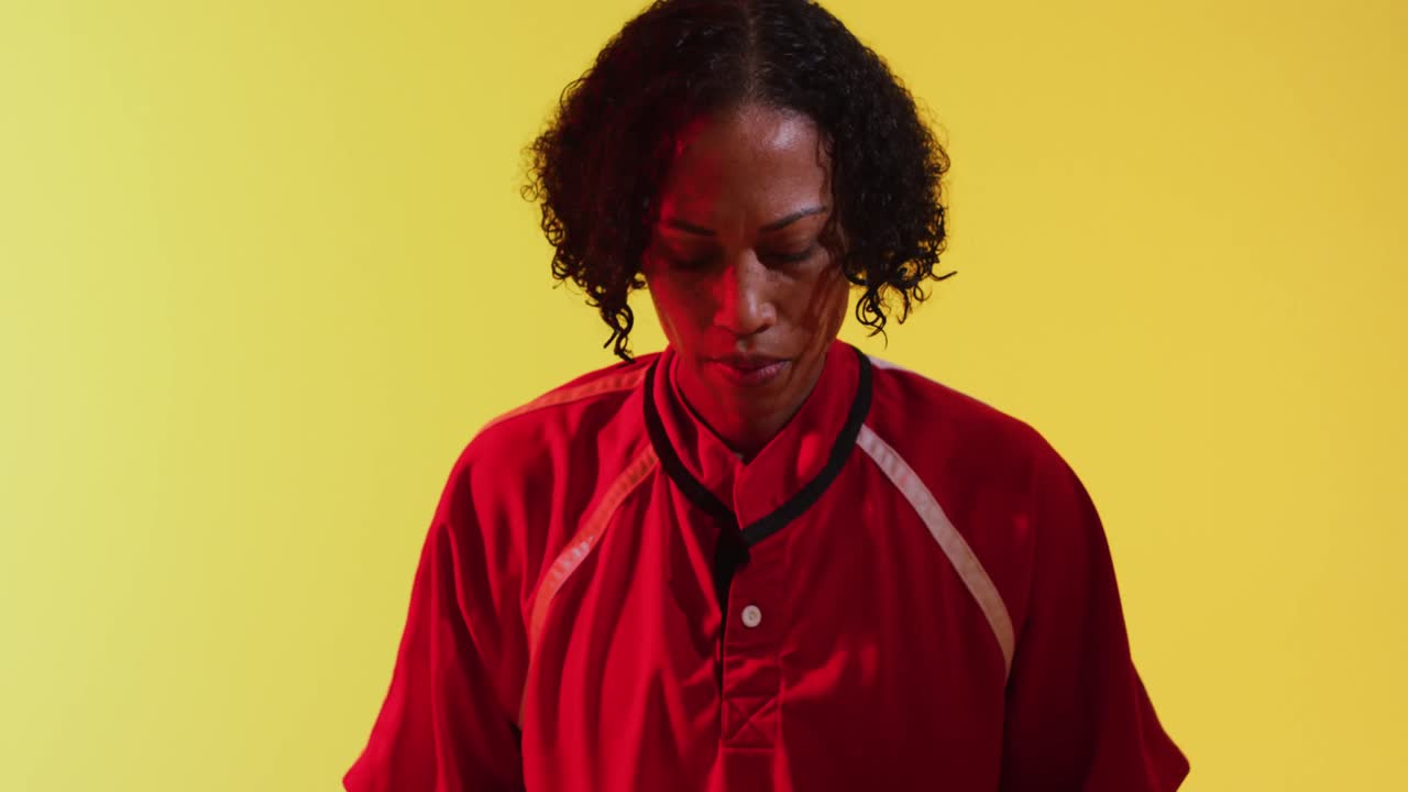 retrato de una jugadora de rugby afroamericana con una pelota de rugby sobre iluminación amarilla de neón