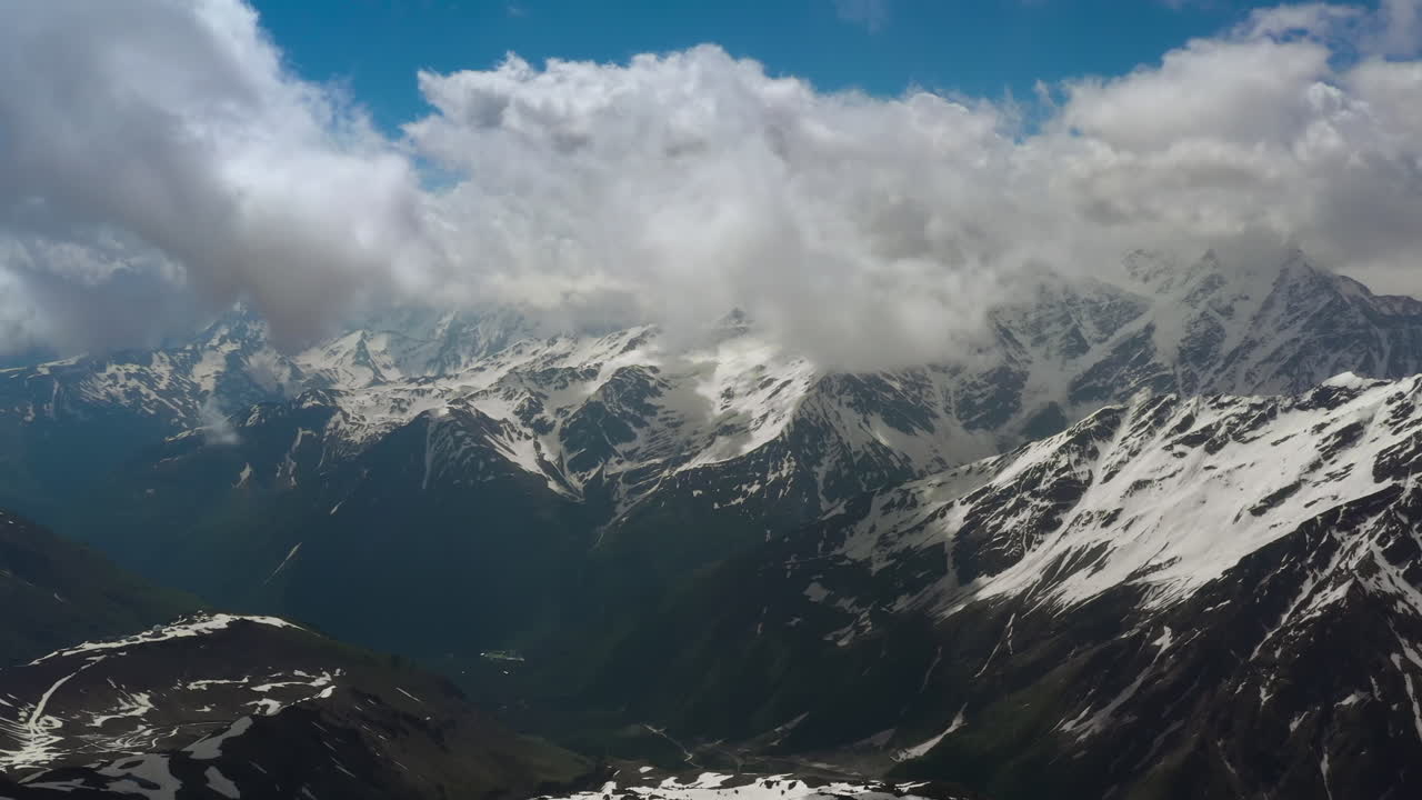 vuelo aéreo a través de nubes montañosas sobre hermosos picos nevados de montañas y glaciares.