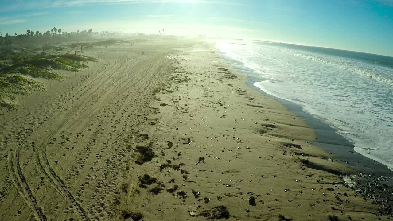 una antena sobre una playa genérica con grandes olas y olas rompiendo