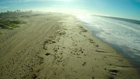 An-aerial-over-a-generic-beach-with-large-waves-and-surf-breaking