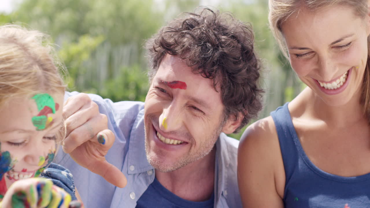 어린 소녀와 함께 행복한 가족은 마당에서 그림을 그리며 엄마와 아빠와 함께 창의적입니다.