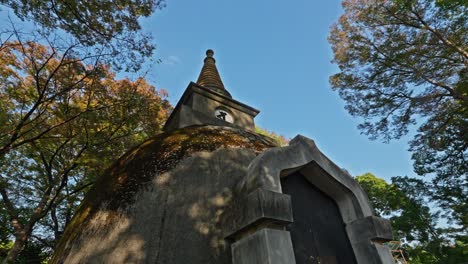the weathered stone of the ueno pagoda is bathed in warm sunlight, surrounded by autumn trees in tokyo's ueno park, a peaceful historical landmark.