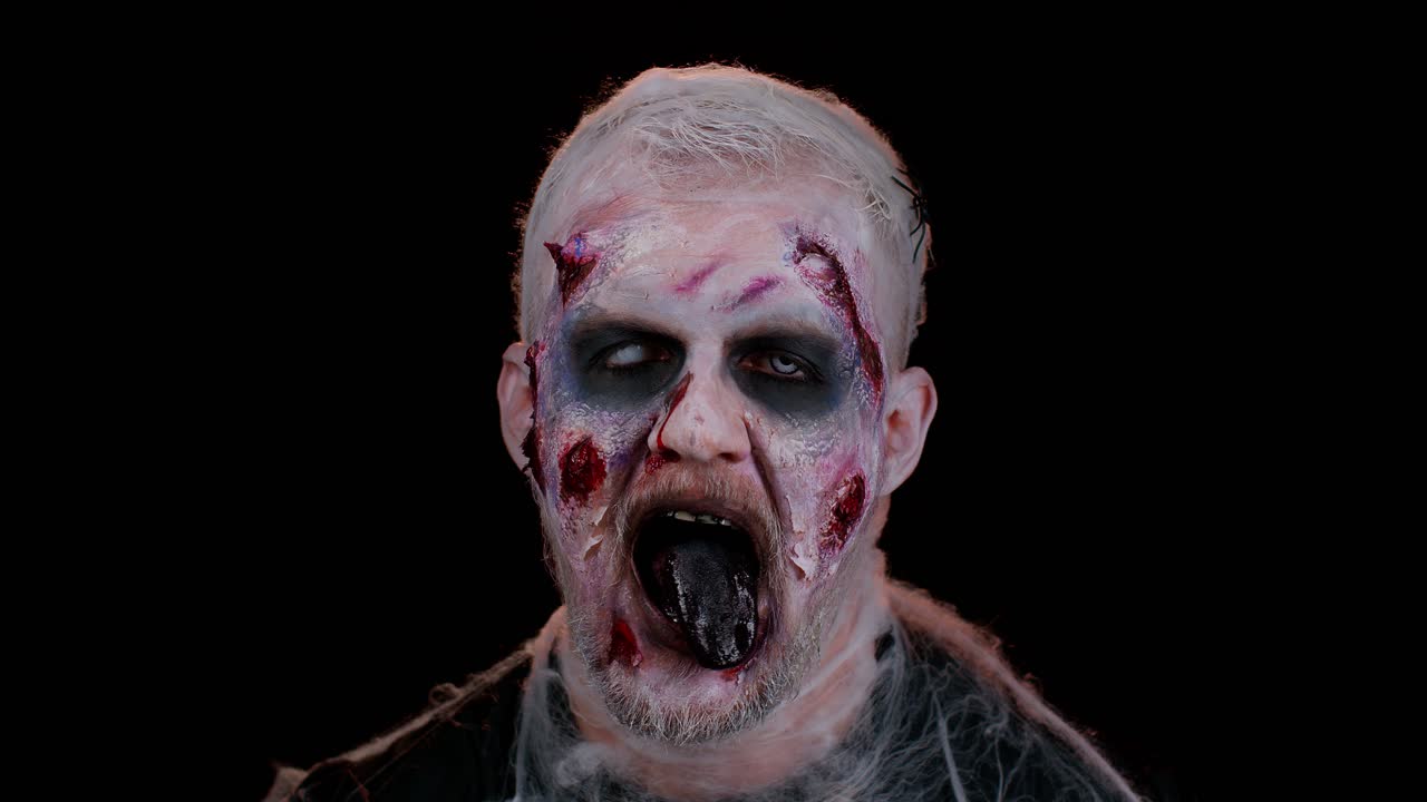hombre aterrador aterrador con halloween zombie sangriento maquillaje herido, mostrando la lengua, tratando de asustar