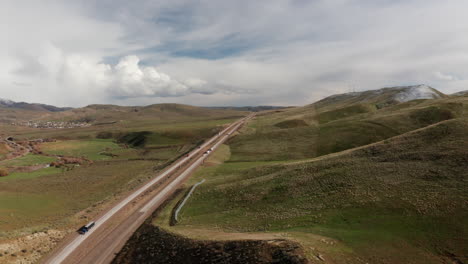 Scenic-aerial-of-interstate-highway-cutting-through-green-mountain-landscape