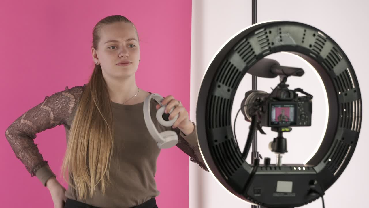 una adolescente grabando un vlog para su canal de estilo de vida hablando de auriculares
