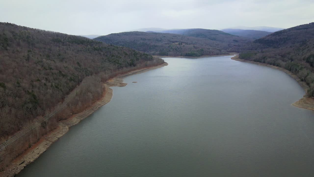 un dron que volaba alto y se desplazaba lateralmente sobre un prístino lago de montaña a principios del invierno en el norte de los apalaches