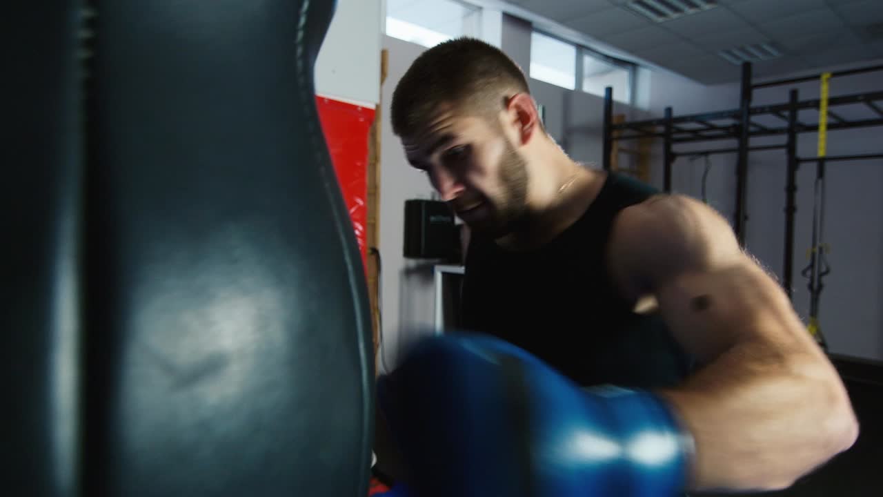 젊은 권투 선수가 펀칭 백에서 펀치를 연습합니다 9