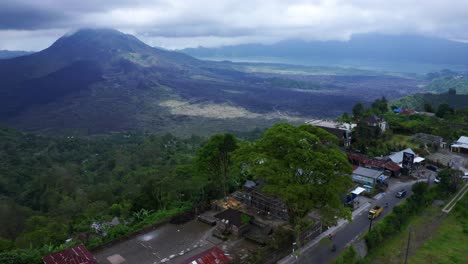 kintamani village road on the hillside with mount batur in the background - bali, indonesia