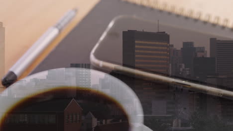 animación del paisaje urbano sobre una taza de café y un teléfono inteligente en el escritorio