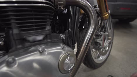 man is cleaning exhaust pipe on his motorcycle with power tools