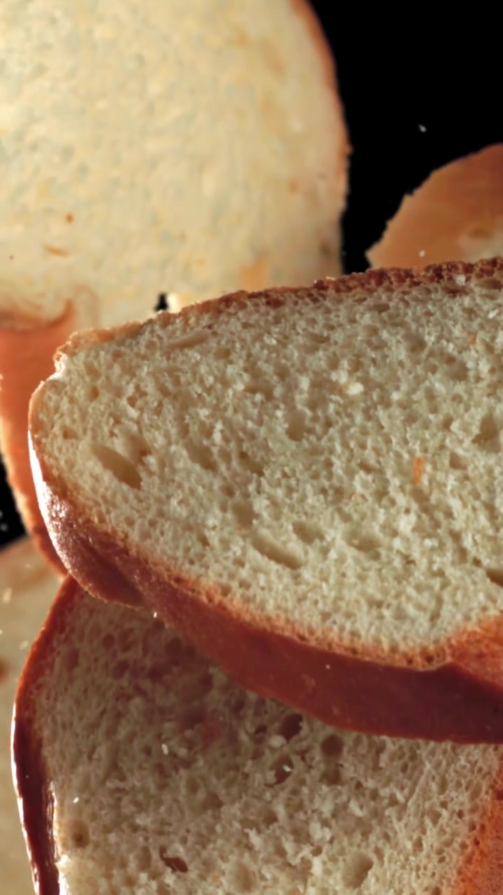 Slow Motion Bread Slices with Falling Crumbs on Black Background