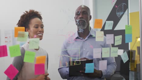 diverse businessman and businesswoman brainstorming and smiling by transparent board with memo notes