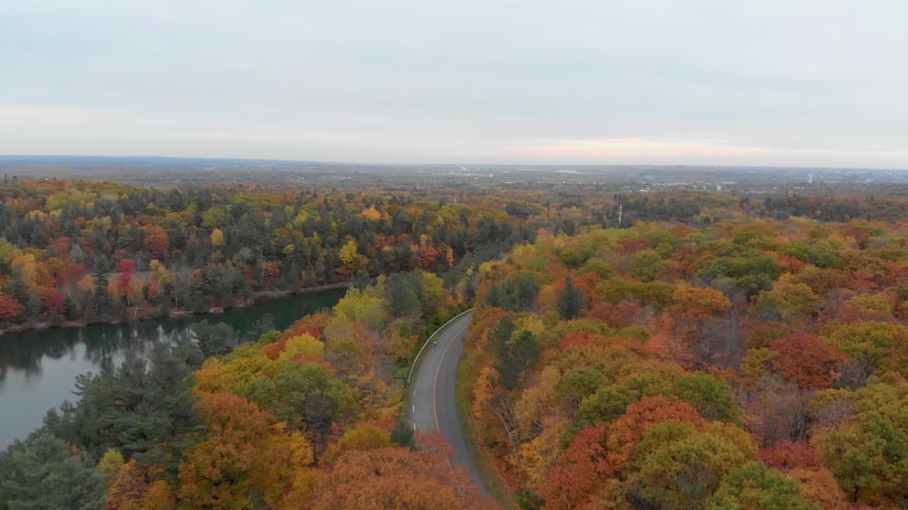 imágenes aéreas sobre el lago rosa en gatineau quebec pasando por el mirador y estacionamiento en la carretera con un motociclista
