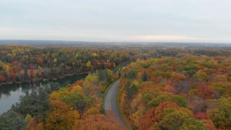 Luftaufnahmen-über-Dem-Pink-Lake-In-Gatineau,-Quebec,-Wie-Man-Mit-Einem-Biker-Den-Aussichtspunkt-Und-Den-Parkplatz-An-Der-Straße-überblickt