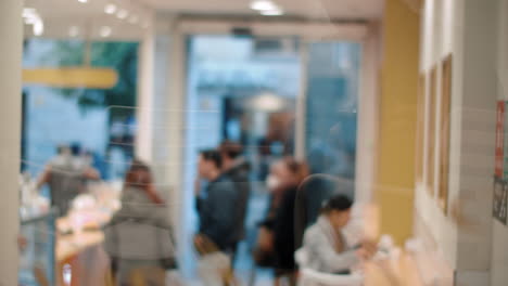 Coffee-shop-visitors-waiting-in-queue-view-through-the-glass