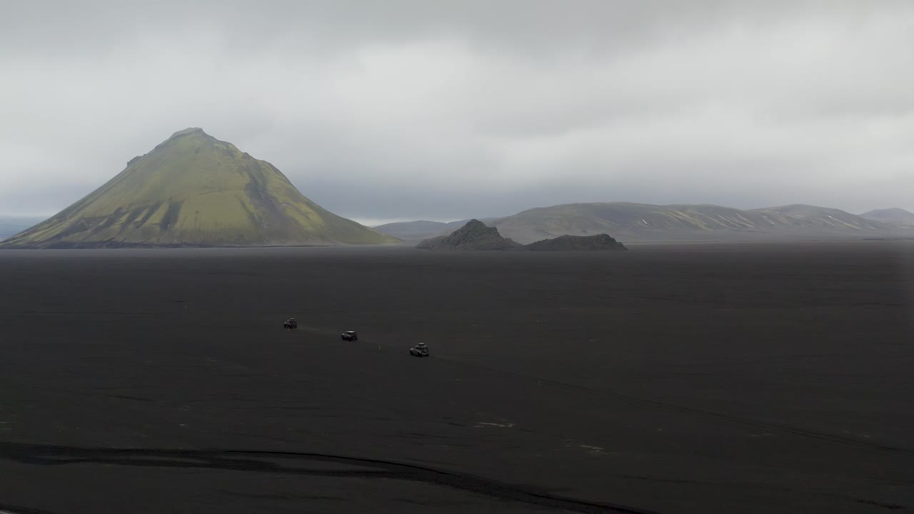 fotografía aérea de automóviles en el paisaje de islandia frente al volcán maelifell durante un día de niebla