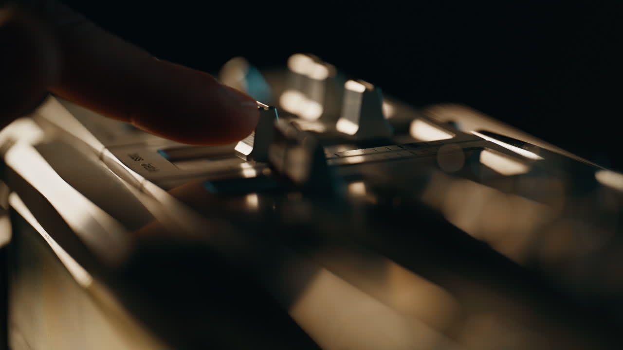 Finger pushing switch retro music player in dark apartment closeup. Man turning