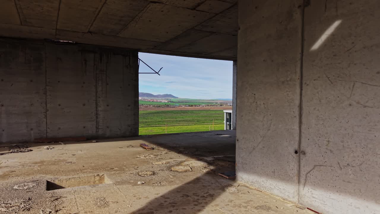 Sweep of green fields and modern building under blue sky