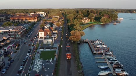 Aerial,-cargo-railway-train-driving-in-rural-American-town,-Wayzata,-Minnesota