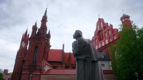 adam mickiewicz statue, st anne's church and bernardine church in vilnius old town in lithuania - panning tilt up shot