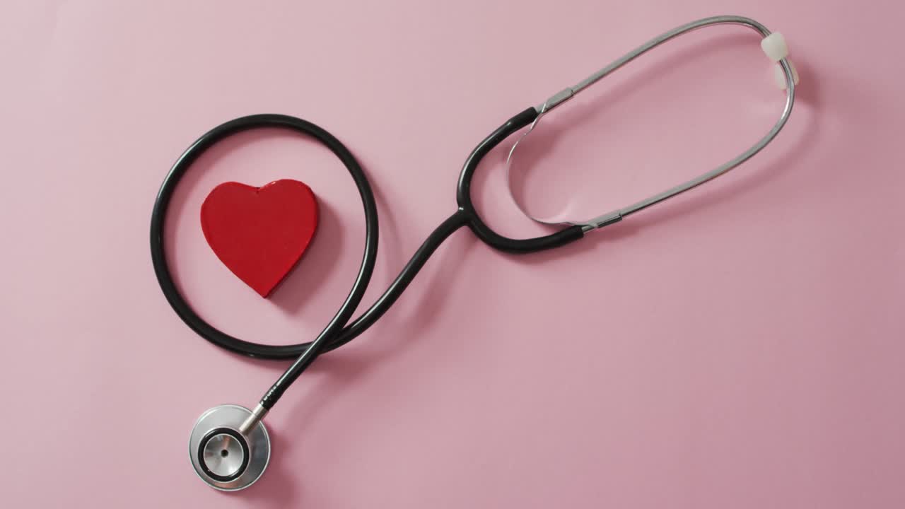 Stethoscope and red heart on pink background at valentine's day