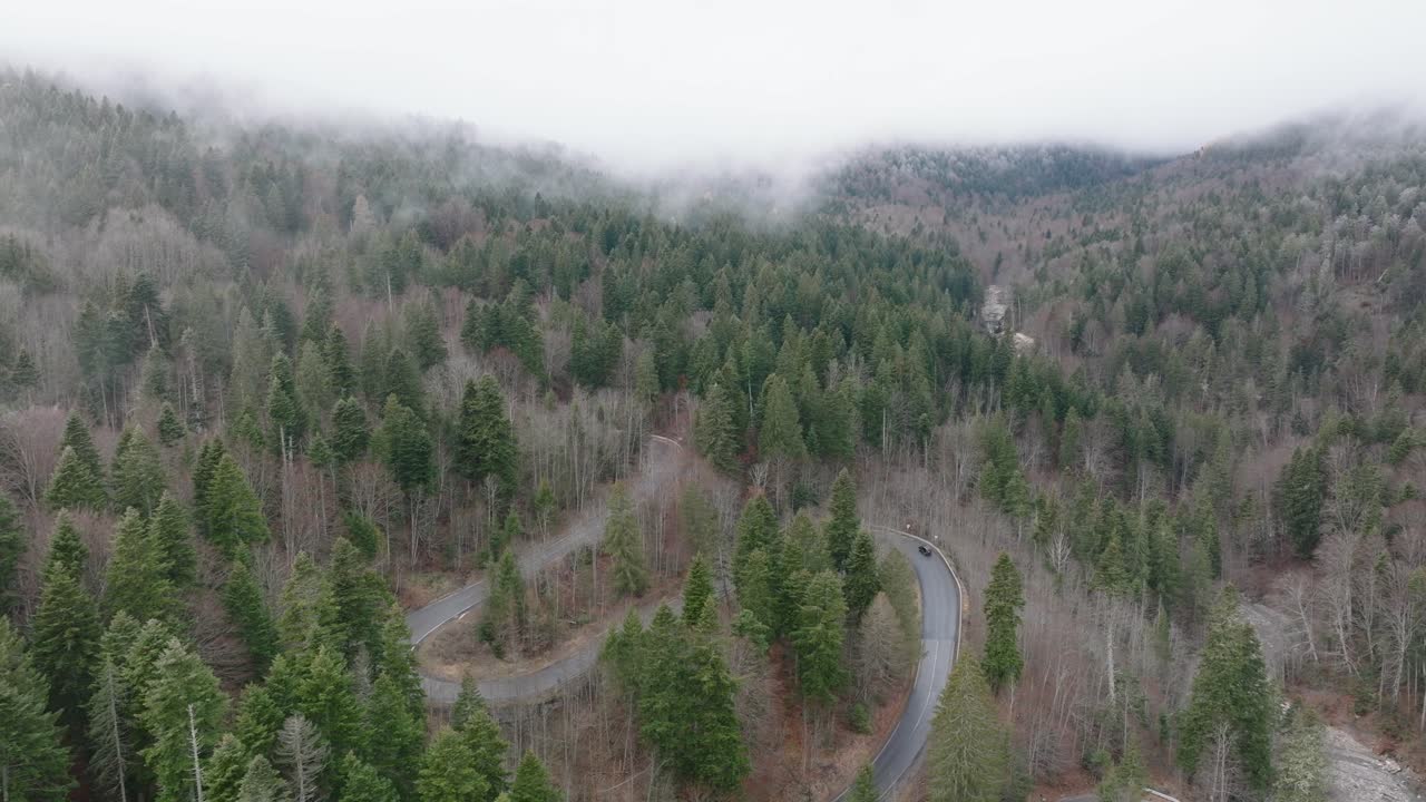 toma aérea en el clima brumoso de la carretera en zigzag en el corazón de las montañas de bucegi, rumania