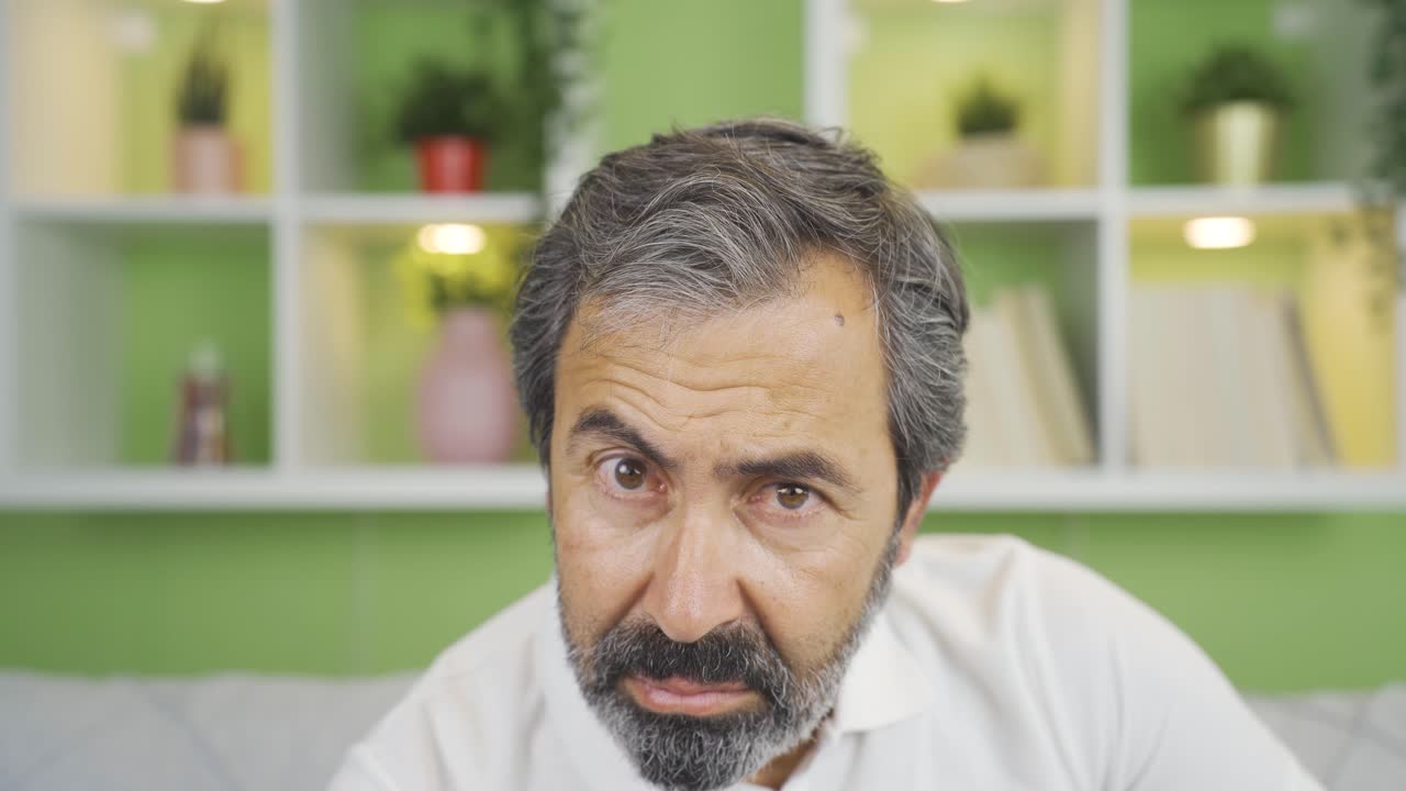 Close-up mature man looking at camera negatively.