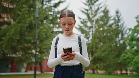 adolescente usando su teléfono inteligente en un parque