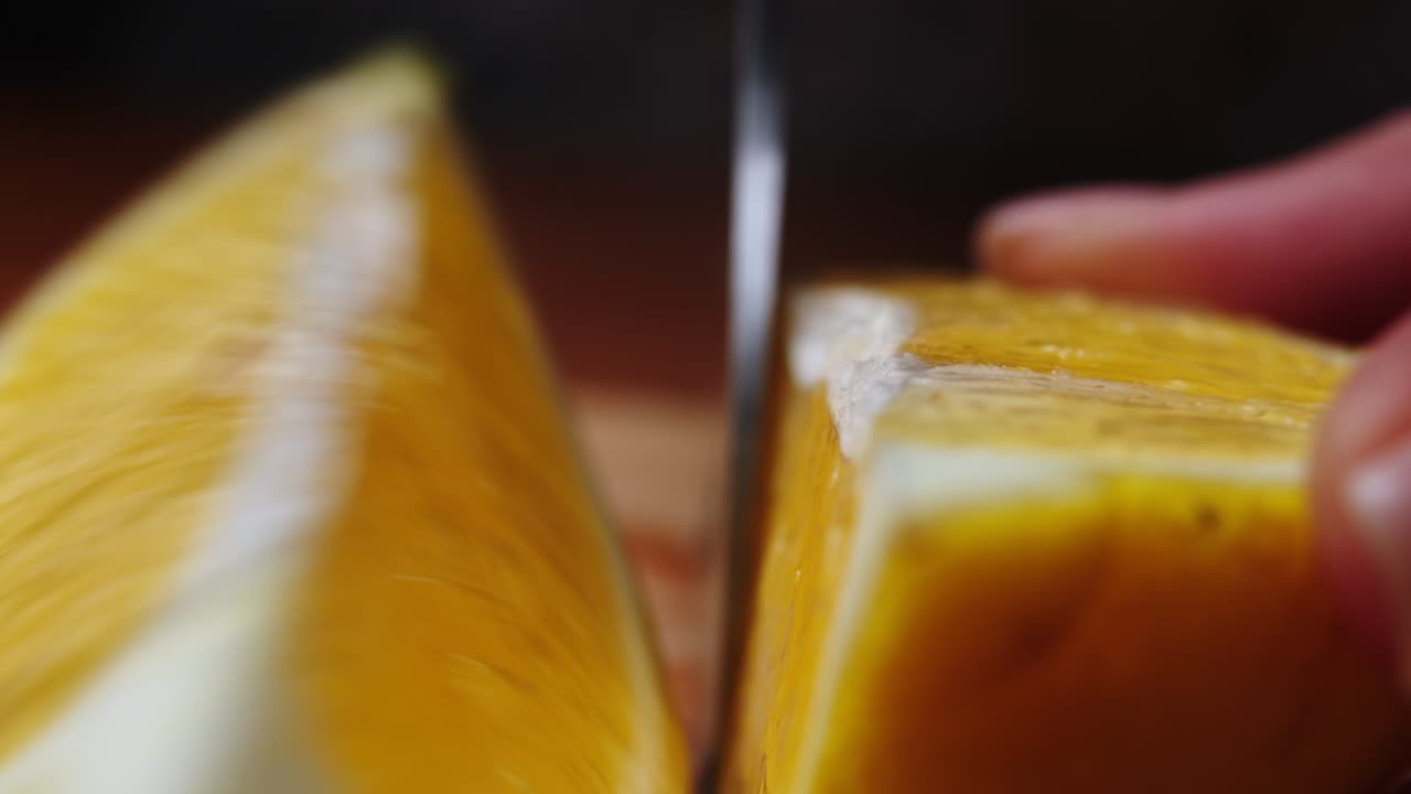 mujer cortando un limón en la tabla de cortar. limón en rodajas a mano en la mesa de cortar de cerca