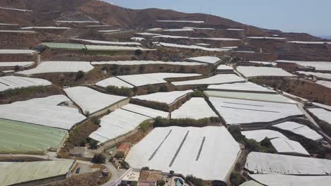 aerial shot of greenhouses in different levels of a mountain in the south of spain