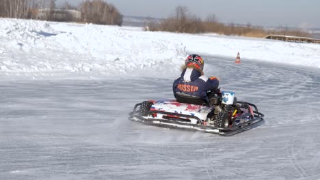 child driving a go-kart on an icy track in winter