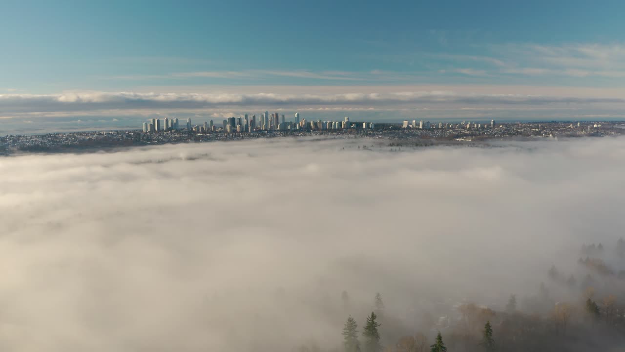 vista aérea del sol brillando sobre un bosque de pinos cubierto de niebla en burnaby, columbia británica, canadá