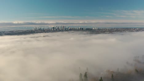 vista aérea del sol brillando sobre un bosque de pinos cubierto de niebla en burnaby, columbia británica, canadá