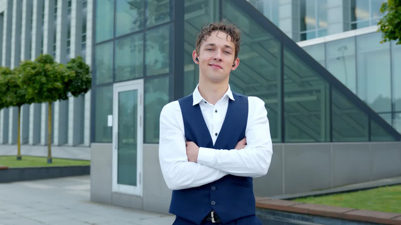 A Young Finance Analyst Smiles, Pleased by What he Hears Through His Earpiece - Medium Shot