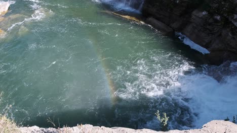 La-Niebla-De-La-Cascada-Crea-Un-Arco-Iris-Vívido-Y-Colorido-Sobre-El-Río-Verde