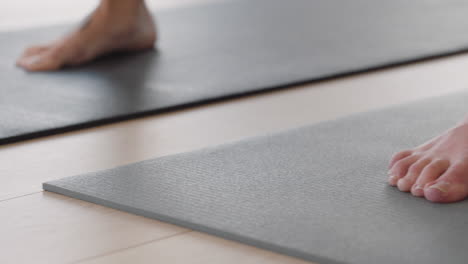 close up feet yoga class group of young women practicing warrior pose meditation on exercise mat enjoying healthy lifestyle training in fitness studio