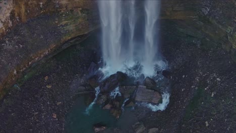 Wasserfall,-Der-Von-Einer-Hohen-Klippe-In-üppiger-Natur-In-Ein-Felsiges-Becken-Stürzt,-Luftaufnahme