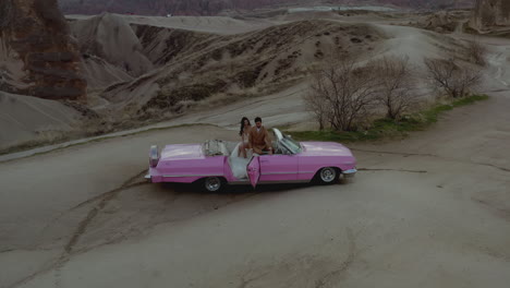 couple in a pink convertible car in cappadocia